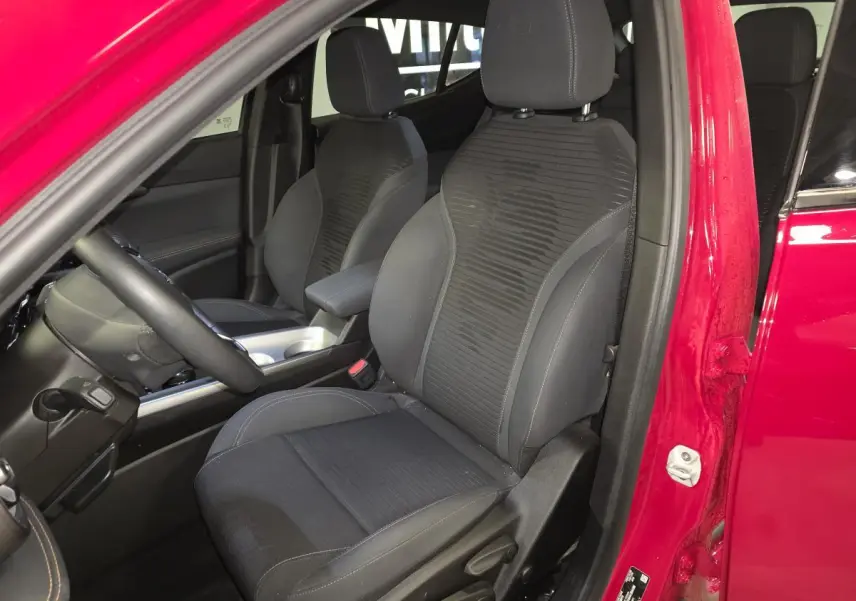 Vue intérieure côté conducteur de l'Alfa Romeo Tonale rouge 2025, sièges tissu noir avec surpiqûres beige et logo Biscione.