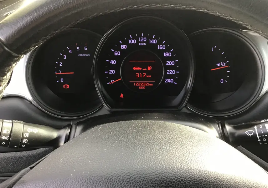 Vue rapprochée du tableau de bord noir de la Kia CEE'D SW 2017, affichant le compteur et l'odomètre à 122232 km.