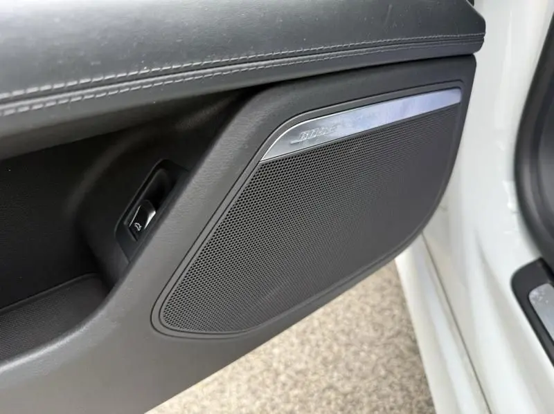 Gros plan sur l'enceinte Bose intégrée à la porte côté gauche d'une Audi A7 Sportback blanche de 2018.