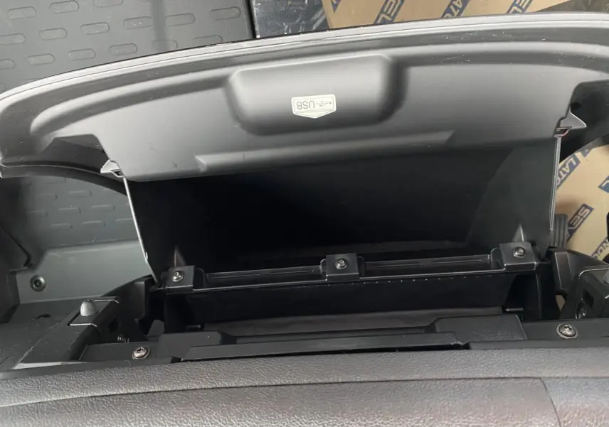 Compartiment de rangement ouvert avec port USB visible sur le tableau de bord noir de l'Opel Movano Fourgon 2022.