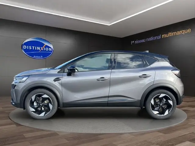 Profil droit du Renault Captur 2025 gris Cassiopée avec toit noir, version hybride full techno, roues au design distinctif.