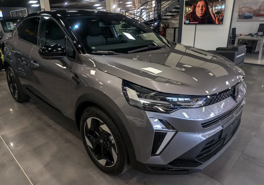 Renault Captur 2025 gris Cassiopé à toit noir, vue 3/4 avant droit, avec jantes biton et éclairage LED distinctif.