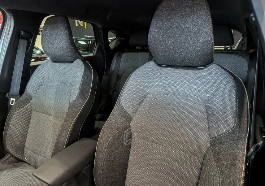 Gros plan sur les sièges avant en tissu gris foncé du Renault Captur 2025, soulignant leur design moderne et confortable.