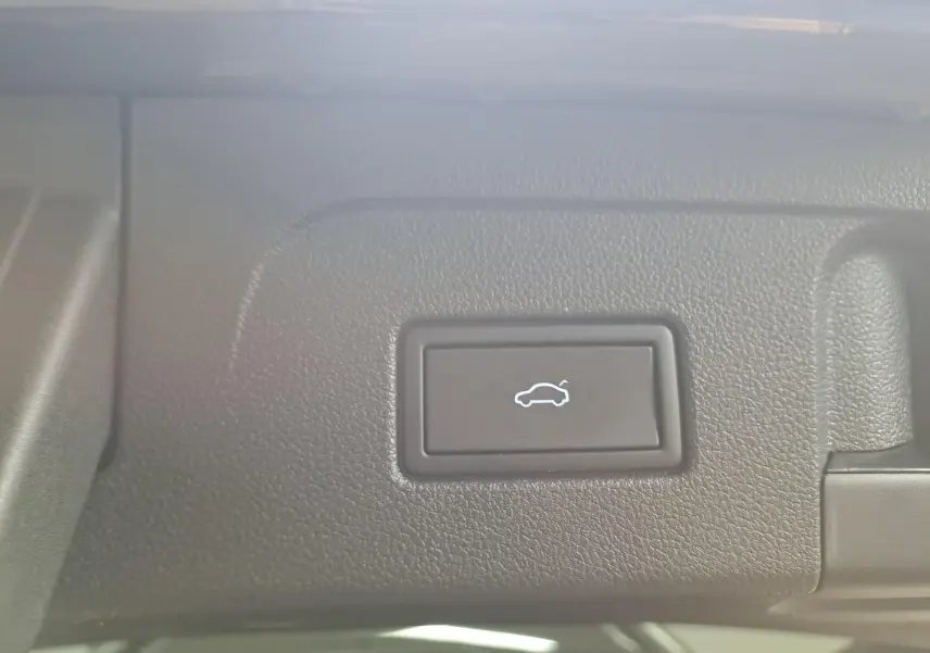 Bouton d'ouverture électrique du hayon sur tableau de bord intérieur du Volkswagen Touran gris Dauphin 2024.
