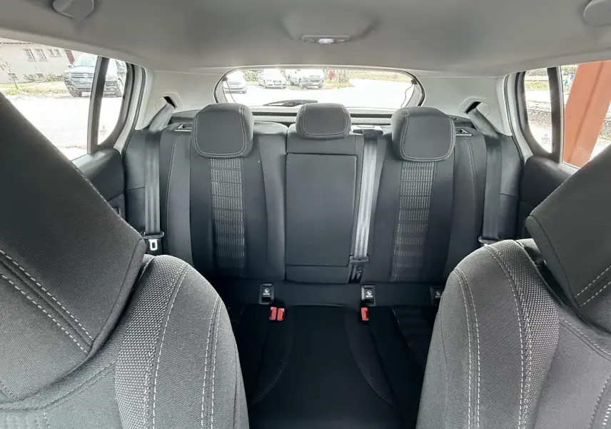 Vue intérieure arrière de la Peugeot 308 2016 montrant les sièges arrière en tissu noir avec appuie-têtes et ceinture centrale.