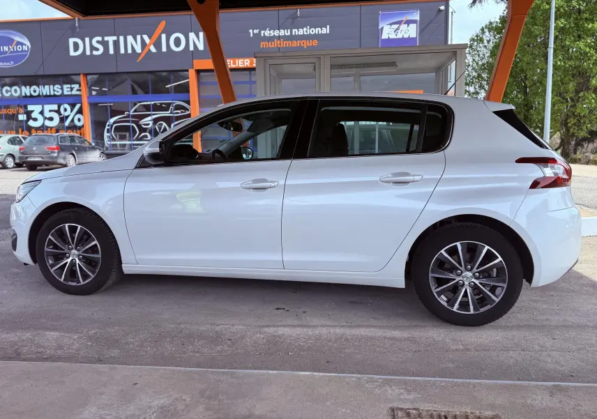 Profil latéral droit d'une Peugeot 308 blanche nacrée 5 portes, avec jantes alliage et vitres teintées.