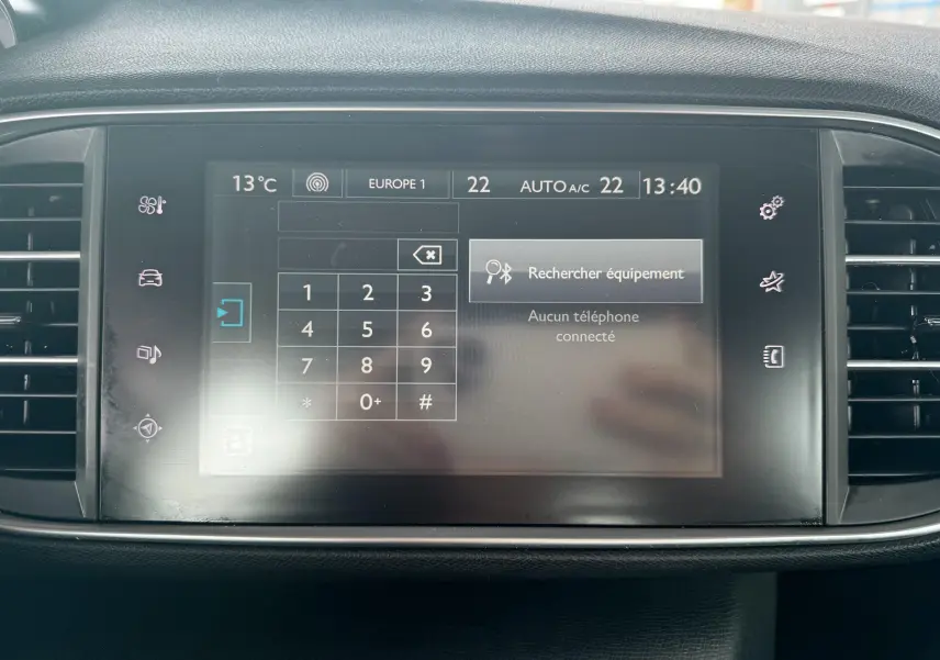 Écran tactile central de la Peugeot 308 2016 affichant la recherche d’équipement Bluetooth, entouré de grilles d’aération noires.