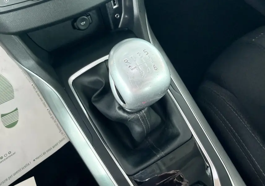 Vue rapprochée du levier de vitesses manuel gris et noir de la Peugeot 308 1.6 BHDI, intérieur tissu noir.