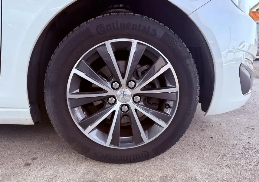 Gros plan sur la roue avant droite d’une Peugeot 308 blanche avec jante alliage et pneu Continental.