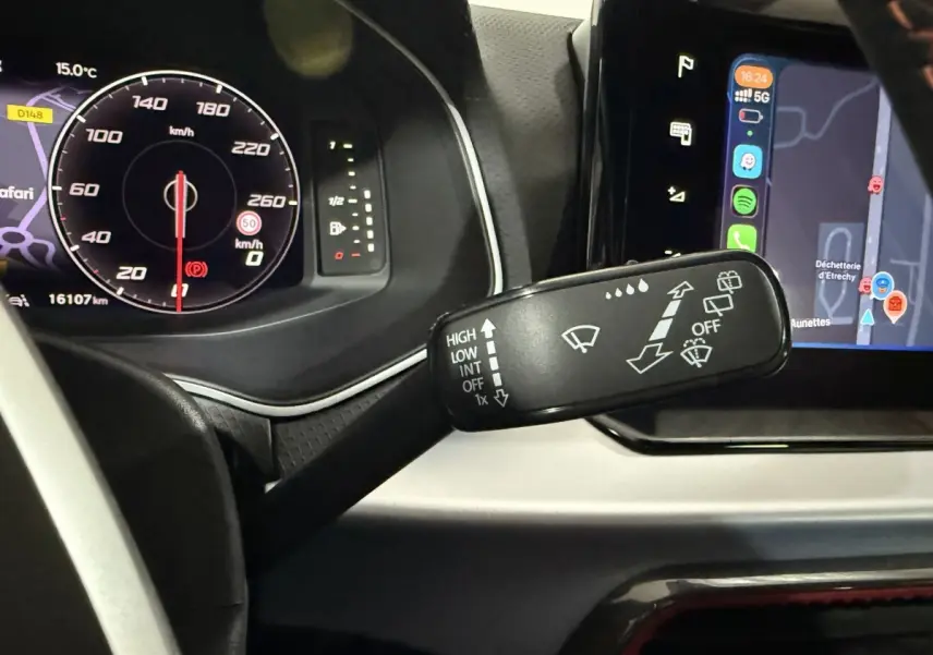 Gros plan sur la commande d’essuie-glaces à gauche du volant dans l’habitacle gris foncé de la SEAT Ibiza 2024.