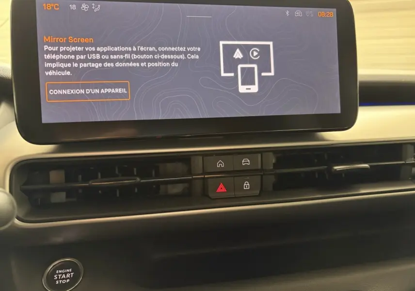 Vue rapprochée du tableau de bord du Jeep Avenger 2025 noir, avec écran tactile central et commandes de climatisation.