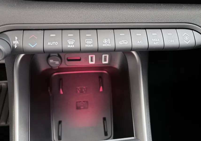 Gros plan sur la console centrale du Jeep Avenger noir, montrant les commandes climatisation et ports USB.