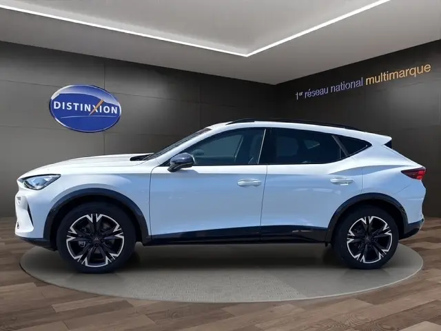Vue latérale droite d'un CUPRA Formentor blanc 2025 en intérieur, soulignant ses jantes noires et détails noirs contrastants.