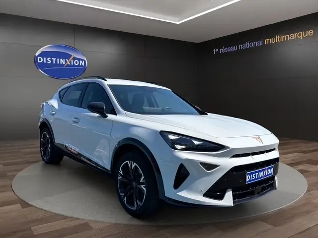 Vue 3/4 avant d'un CUPRA Formentor blanc 2025 en intérieur, avec jantes noires et calandre marquée.