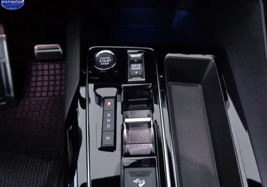 Vue rapprochée de la console centrale noire brillante du Peugeot 3008 gris platinium, avec bouton start et sélecteur de mode de conduite.