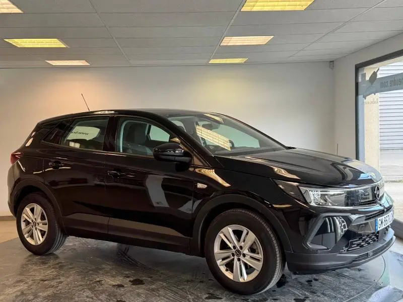 Opel Grandland noir Karbon métallisé vu de côté gauche en intérieur, avec jantes alu et phares LED distinctifs.