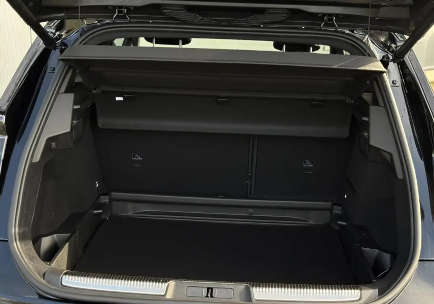 Coffre ouvert vu de l'arrière d'un DS7 noir Perla, montrant un espace de chargement propre et bien fini.