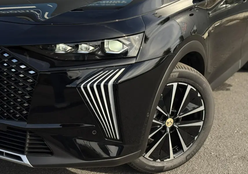 Gros plan sur l'avant droit noir Perla du DS7 2025, mettant en valeur les phares et jantes alliage 19'' Edinburgh.
