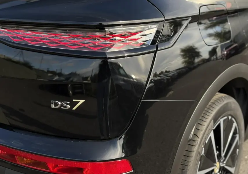 Gros plan sur l'arrière droit noir Perla du DS7 2025, mettant en valeur le feu arrière 3D et le logo DS7.