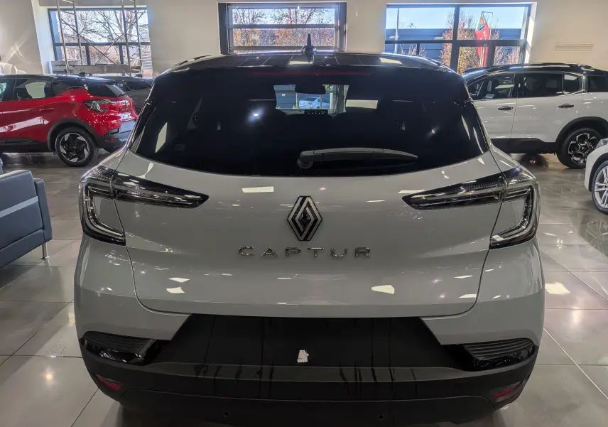 Vue arrière d'un Renault Captur gris Rafale avec toit noir, mettant en valeur ses feux arrière LED et son logo central.