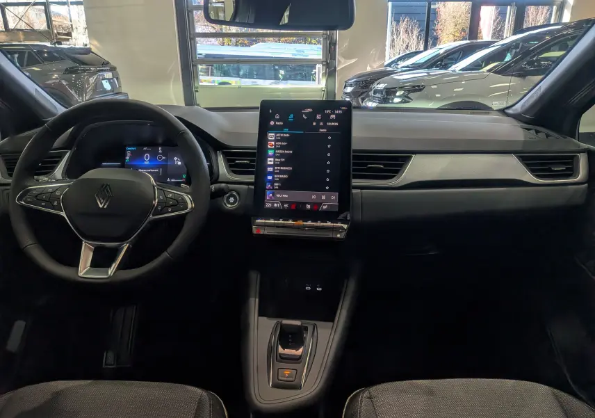 Tableau de bord et volant du Renault Captur 2025, vue frontale intérieure avec écran tactile central vertical.