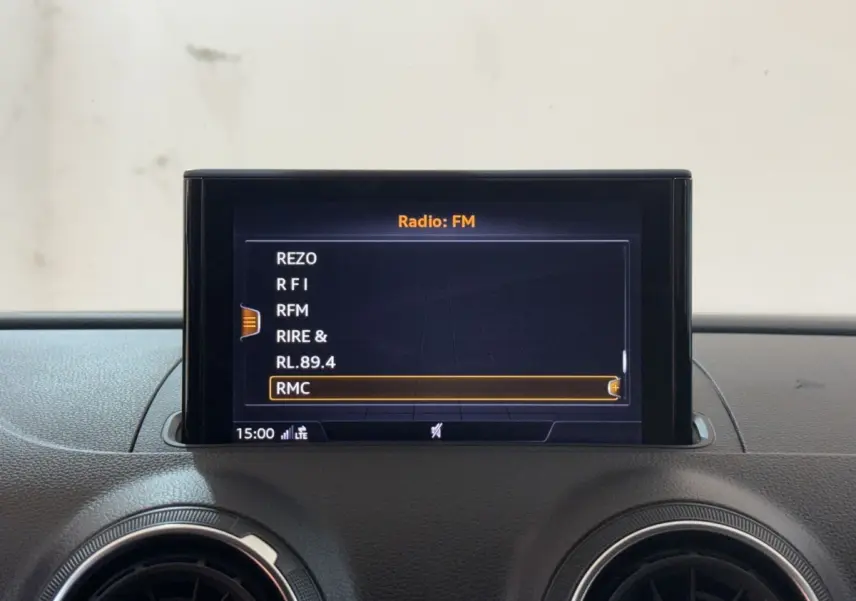 Écran central de l’Audi A3 2.0 TDI 2018 affichant les stations radio FM avec tableau de bord noir.