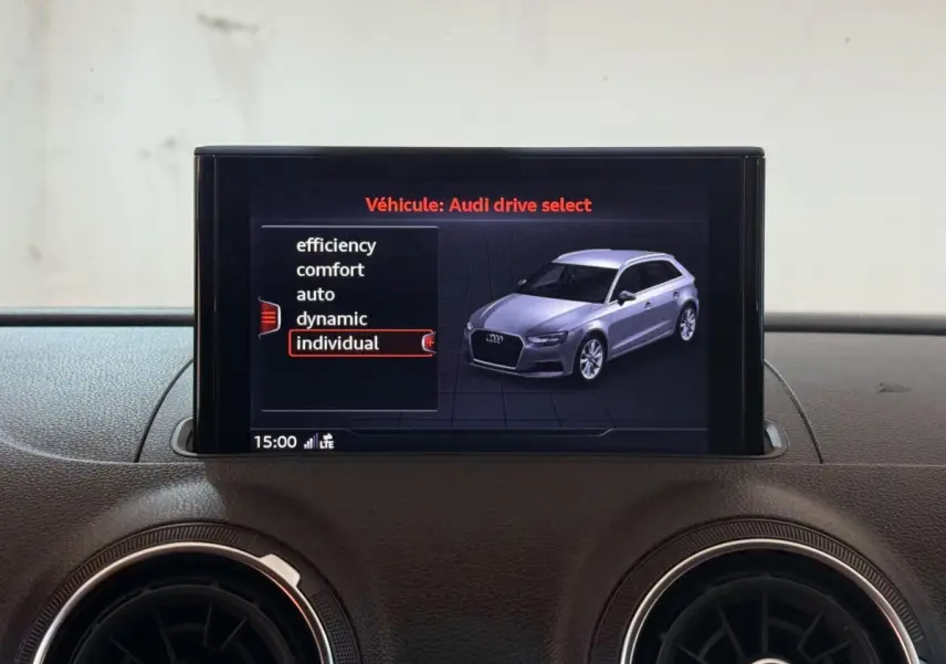 Écran central affichant le menu Audi drive select avec une vue 3D d'une Audi A3 grise en profil avant droit.