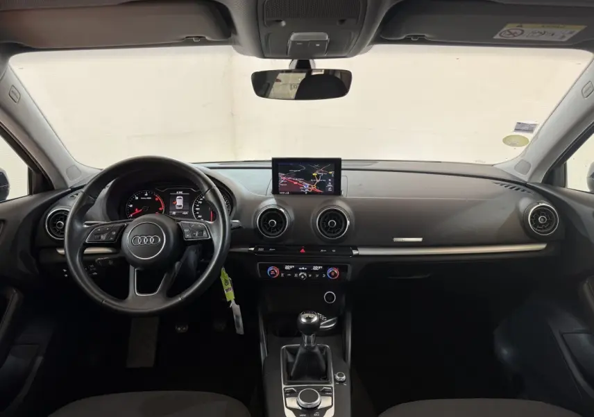 Vue intérieure avant de l'Audi A3 2.0 TDI 2018 avec tableau de bord noir et écran central de navigation.