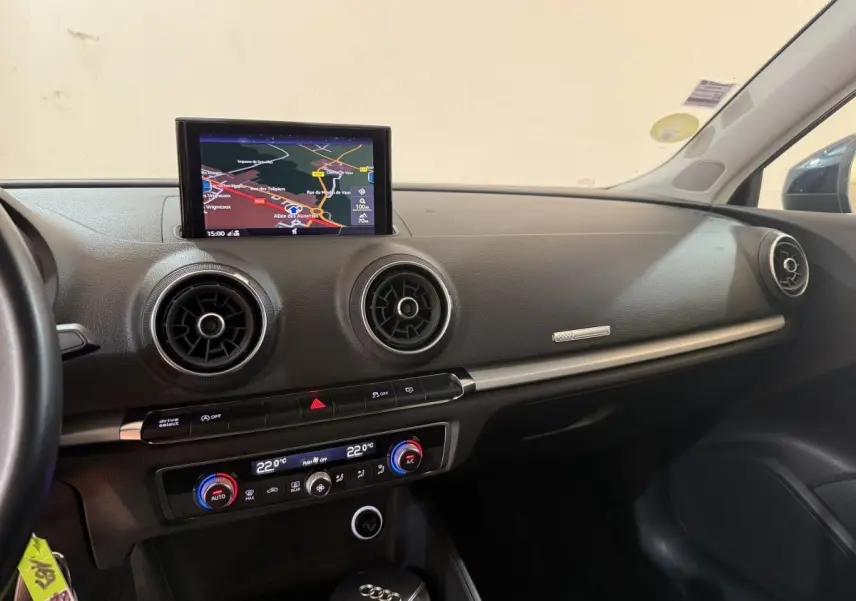 Vue intérieure côté passager de l'Audi A3 2.0 TDI 2018 avec écran navigation et aérateurs ronds noirs.