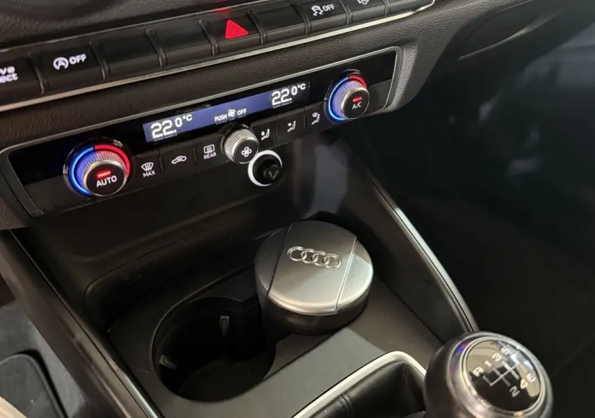 Gros plan intérieur sur la console centrale de l'Audi A3 Business Line 2018, avec climatisation digitale et levier de vitesse manuel.
