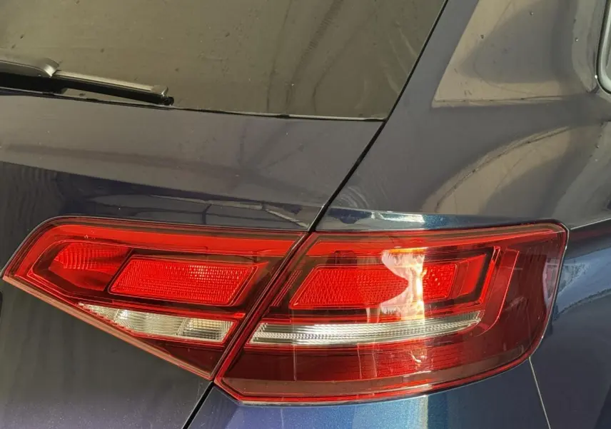 Gros plan sur le feu arrière droit d’une Audi A3 bleu métallisé, soulignant les lignes nettes et le vitrage teinté.