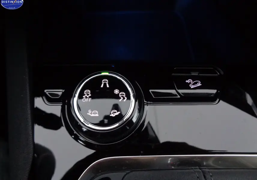 Gros plan sur la molette de sélection des modes de conduite et le bouton d'assistance à la descente dans un Peugeot 3008 noir perle métal.