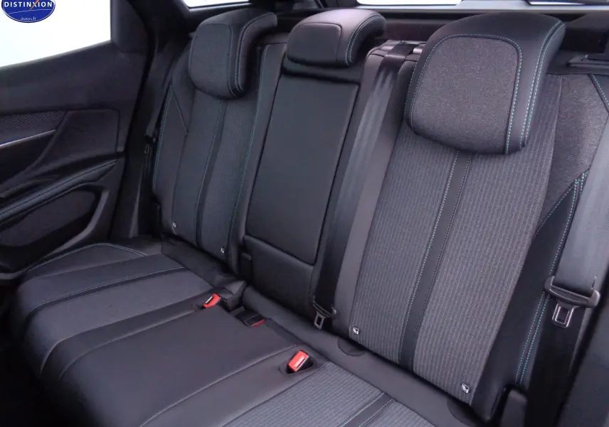 Vue intérieure arrière des sièges arrière du Peugeot 3008 2023, tissu gris avec surpiqûres bleues et ceintures noires.