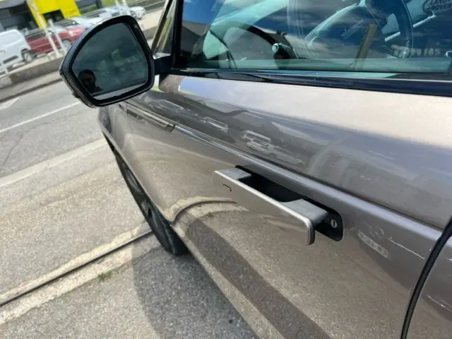 Poignée de porte rétractable côté gauche d'un Range Rover Velar marron 2018, vue rapprochée en extérieur.