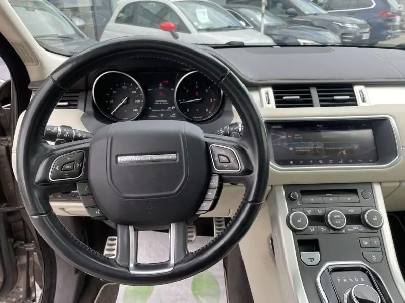 Vue intérieure centrée sur le volant noir du Range Rover Evoque marron métal 2017 avec tableau de bord et console tactile.