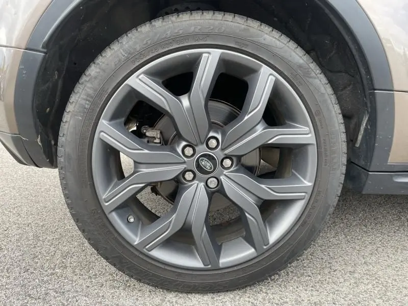 Gros plan sur la roue avant gauche du Range Rover Evoque marron métal, mettant en valeur la jante en alliage au design moderne.