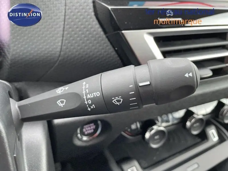 Gros plan sur la commande des essuie-glaces dans l'habitacle gris d'une Citroën C4 Hybride 2024.