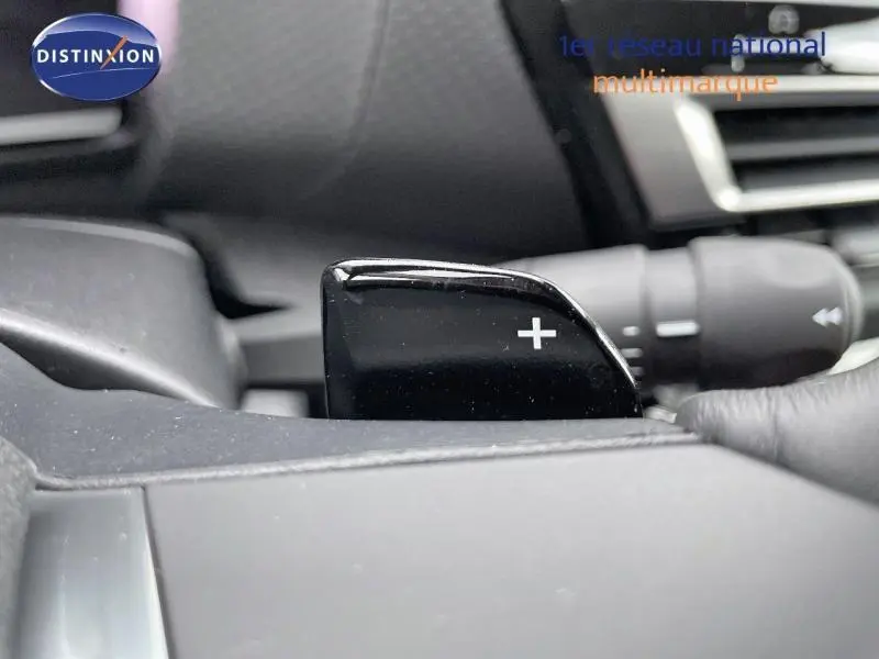 Gros plan sur la palette de changement de vitesse "+" noire du volant cuir d'une Citroën C4 gris 2024.