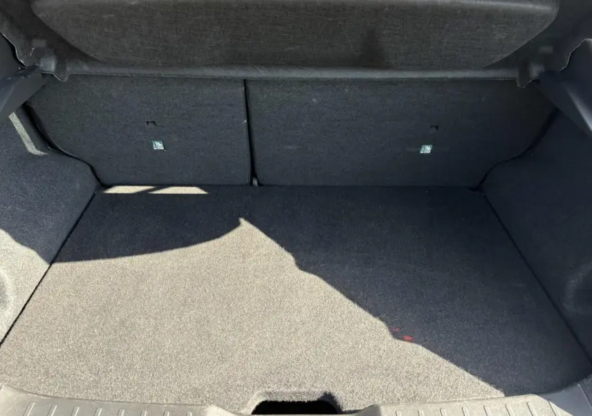 Coffre spacieux et vide du Nissan Juke 2024 gris Dark Metal, vue intérieure arrière avec banquette rabattable.