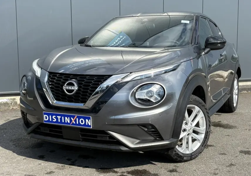 Nissan Juke gris Dark Metal en 3/4 avant droit, avec calandre chromée et jantes alliage 17 pouces visibles.