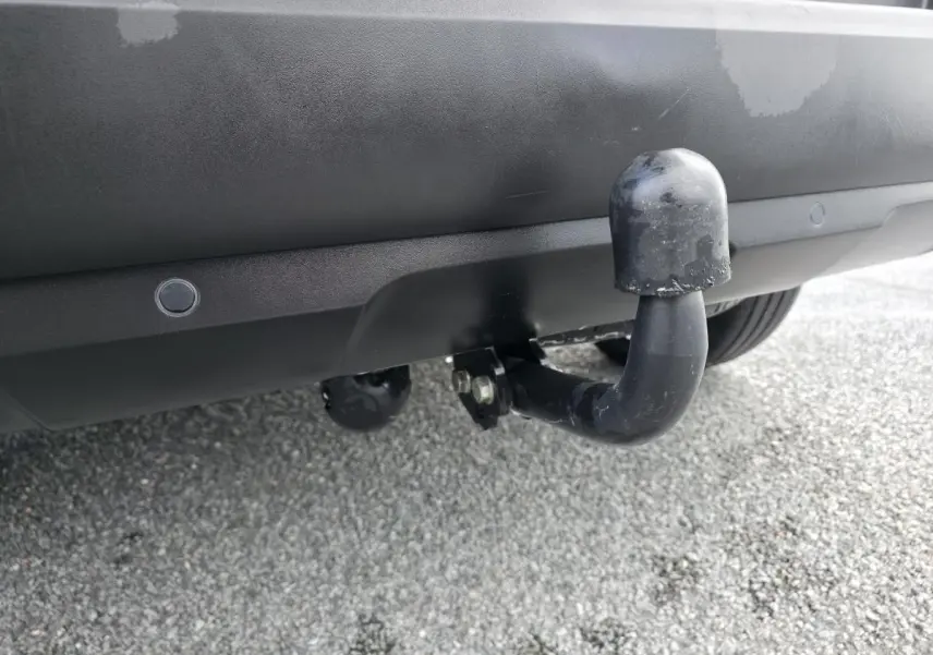 Gros plan sur l'attelage noir fixé au pare-chocs arrière noir du Peugeot 5008 Diesel 2021.