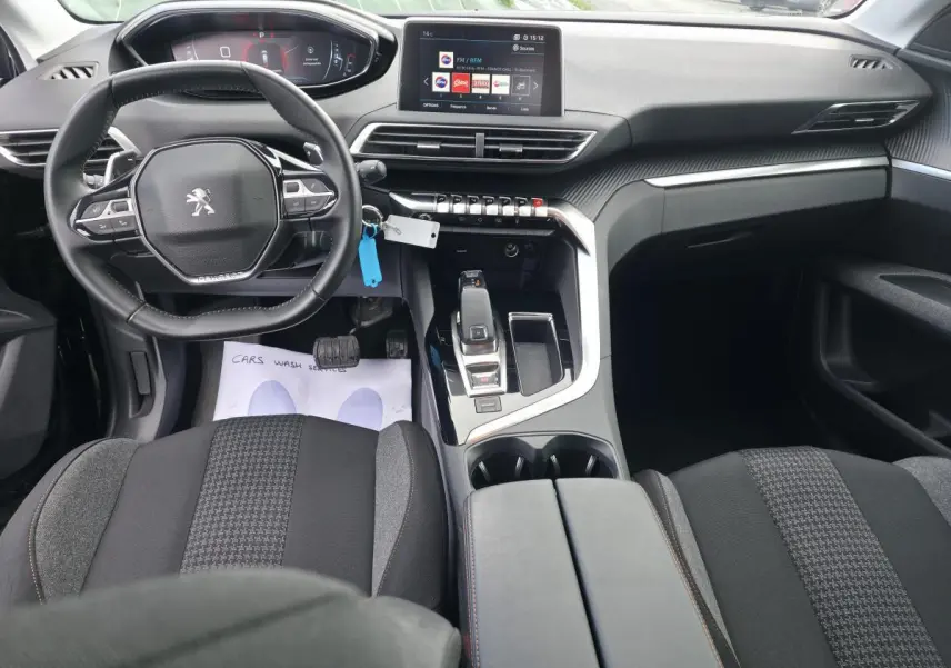 Intérieur du Peugeot 5008 2021 vu de face, volant compact, planche de bord carbone et écran tactile 10 pouces.