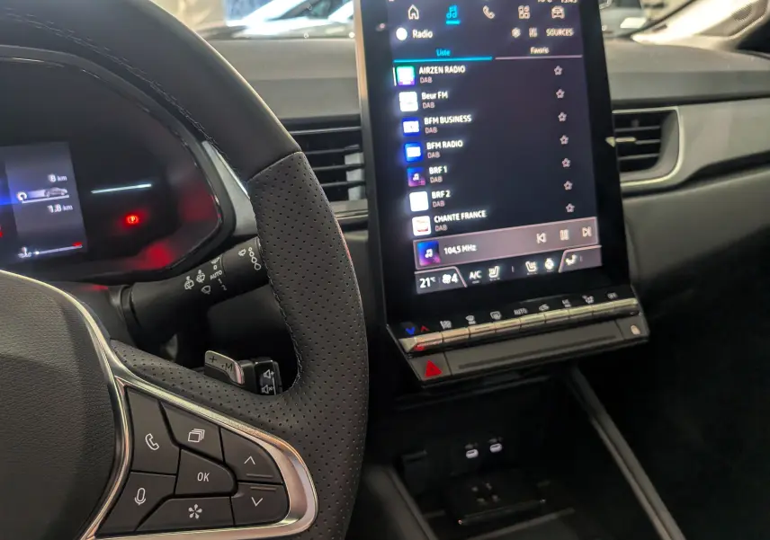 Intérieur du Renault Captur 2025, vue du volant et écran central tactile affichant les stations radio.