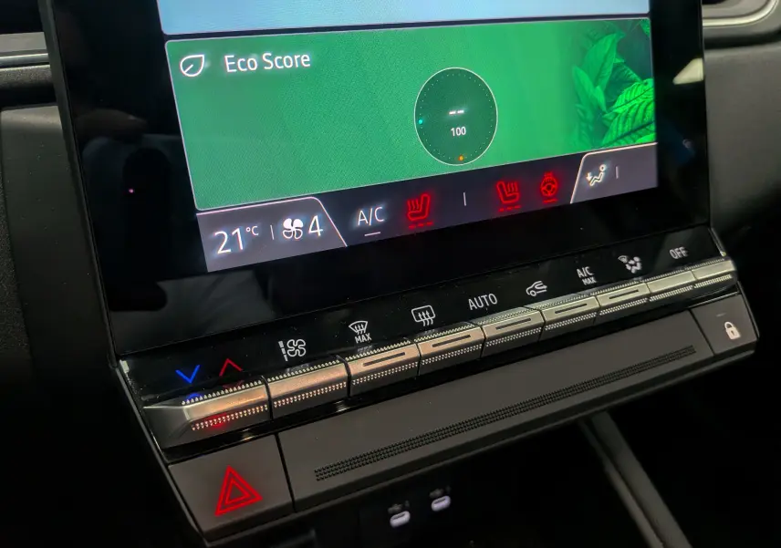 Gros plan sur la console centrale du Renault Captur 2025, affichant l'écran tactile avec réglages climatisation et boutons lumineux.