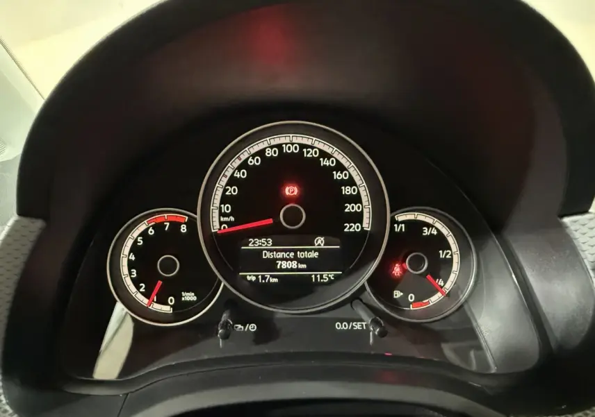 Gros plan sur le tableau de bord noir du Volkswagen Up 1.0 65 Active, affichant vitesse, compte-tours et jauge carburant.