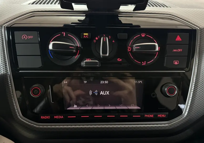 Vue rapprochée du tableau de bord noir du Volkswagen Up 1.0 65 Active 2022, avec commandes climatisation et écran multimédia.