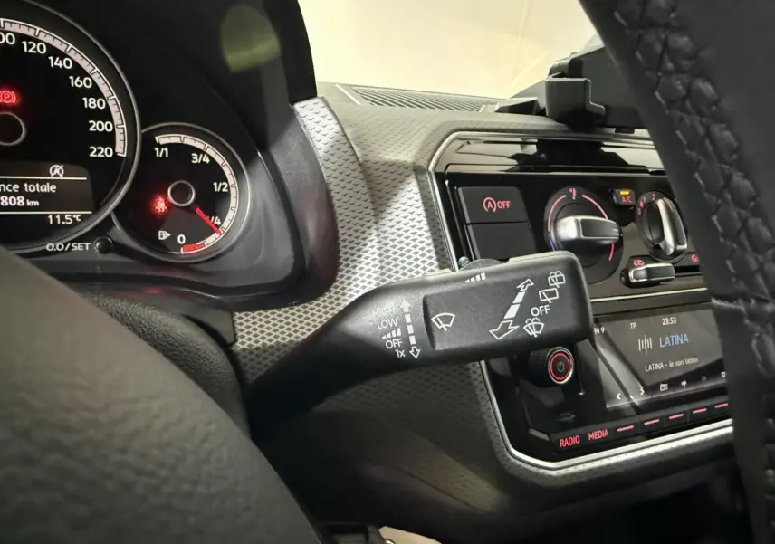 Vue rapprochée de l'intérieur du Volkswagen Up 2022, montrant le tableau de bord gris et la commande d'essuie-glace.