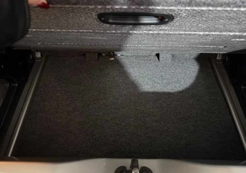 Vue intérieure du coffre gris foncé d'une Volkswagen Up 1.0 65 Active, montrant le revêtement et la tablette de séparation.