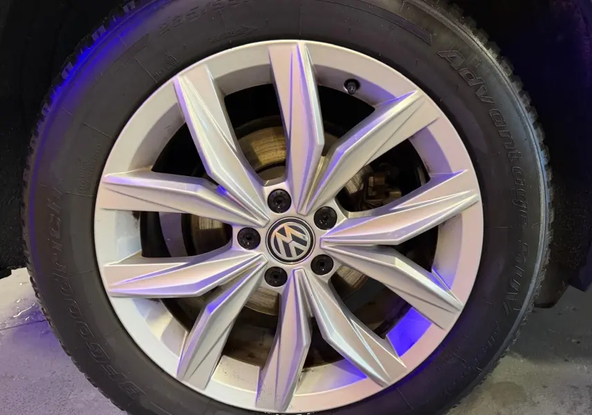 Gros plan sur la jante alu argentée d’un Volkswagen Tiguan gris, avec logo VW au centre et pneu BFGoodrich.