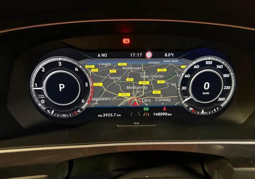Tableau de bord numérique du Volkswagen Tiguan 2018, affichant la carte GPS et compteurs ronds blancs sur fond noir.